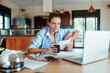 © Geber86 - Focused Woman Working from Home with Laptop and Papers