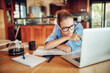© Geber86 - Focused Woman Working from Home with Laptop and Papers