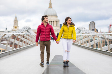 Poster - UK, London, young couple walking hand in hand on bridge in front of St Pauls Cathedral