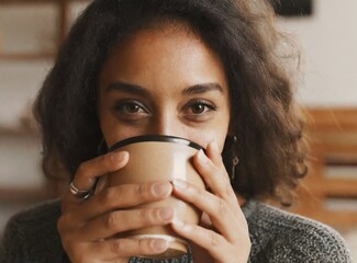 Canvas Print - Portrait of a brunette Latin woman drinking cup of coffee at home, relax on winter holiday concept