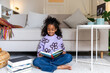 © Strathmore - POC girl sitting in livingroom enjoying reading a book
