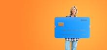 Smiling Woman Standing With Credit Card On Empty Orange Background