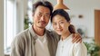 © Z A C - At home, an Asian couple in their middle age wraps themselves in a loving embrace, radiating happiness.