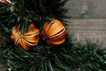 Christmas Background Pine Tree With Dried Tangerines Wooden Background. The Combination Of The Pine Tree, Ornaments, And Greenery Creates A Classic And Cozy Setting.