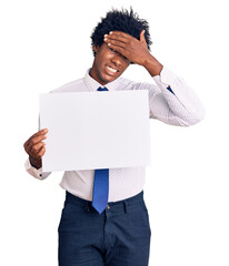 Canvas Print - Handsome african american man with afro hair holding blank empty banner stressed and frustrated with hand on head, surprised and angry face