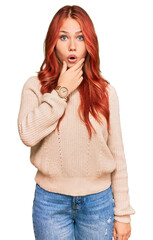 Poster - Young redhead woman wearing casual winter sweater looking fascinated with disbelief, surprise and amazed expression with hands on chin