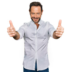 Poster - Middle age man wearing casual clothes approving doing positive gesture with hand, thumbs up smiling and happy for success. winner gesture.