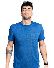 Canvas Print - Young hispanic man wearing casual t shirt looking at the camera blowing a kiss on air being lovely and sexy. love expression.