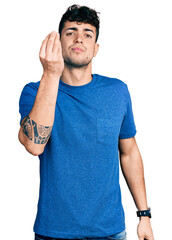 Poster - Young hispanic man wearing casual t shirt doing italian gesture with hand and fingers confident expression