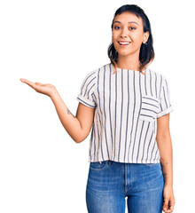 Sticker - Young woman wearing casual clothes smiling cheerful presenting and pointing with palm of hand looking at the camera.