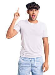 Poster - Young hispanic man wearing casual clothes pointing finger up with successful idea. exited and happy. number one.