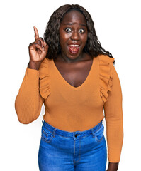 Poster - Young african woman wearing casual clothes pointing finger up with successful idea. exited and happy. number one.