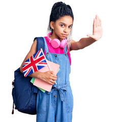 Sticker - Cute african american girl wearing student backpack holding united kingdom flag with open hand doing stop sign with serious and confident expression, defense gesture