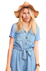 Wall Mural - Young beautiful blonde woman wearing summer hat and dress depressed and worry for distress, crying angry and afraid. sad expression.