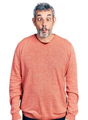 Poster - Middle age hispanic with grey hair wearing casual sweater making fish face with lips, crazy and comical gesture. funny expression.