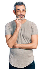 Poster - Middle age hispanic with grey hair wearing casual grey t shirt looking confident at the camera with smile with crossed arms and hand raised on chin. thinking positive.