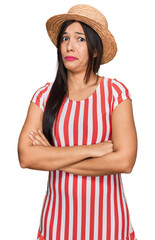 Sticker - Young hispanic woman wearing summer hat skeptic and nervous, disapproving expression on face with crossed arms. negative person.