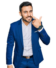 Canvas Print - Young hispanic man wearing business jacket pointing with hand finger to face and nose, smiling cheerful. beauty concept