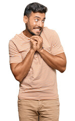 Canvas Print - Handsome hispanic man wearing casual clothes laughing nervous and excited with hands on chin looking to the side