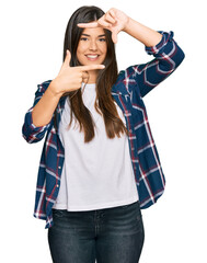 Poster - Young brunette woman wearing casual clothes smiling making frame with hands and fingers with happy face. creativity and photography concept.