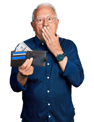 Wall Mural - Senior man with grey hair holding leather wallet covering mouth with hand, shocked and afraid for mistake. surprised expression