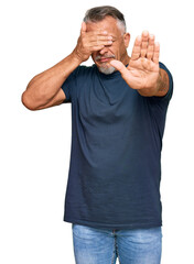 Sticker - Middle age grey-haired man wearing casual clothes covering eyes with hands and doing stop gesture with sad and fear expression. embarrassed and negative concept.