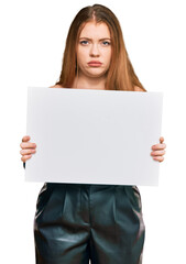 Poster - Young beautiful redhead woman holding blank empty banner thinking attitude and sober expression looking self confident