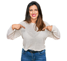 Canvas Print - Beautiful hispanic woman wearing casual sweater looking confident with smile on face, pointing oneself with fingers proud and happy.