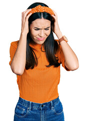 Wall Mural - Young hispanic woman wearing casual clothes suffering from headache desperate and stressed because pain and migraine. hands on head.