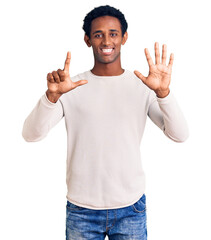 Wall Mural - African handsome man wearing casual winter sweater showing and pointing up with fingers number seven while smiling confident and happy.