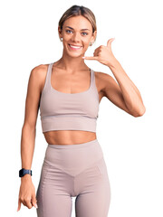 Wall Mural - Beautiful caucasian woman wearing sportswear smiling doing phone gesture with hand and fingers like talking on the telephone. communicating concepts.