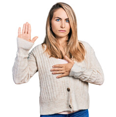 Wall Mural - Young blonde woman wearing casual clothes swearing with hand on chest and open palm, making a loyalty promise oath