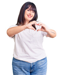 Sticker - Young plus size woman wearing casual clothes smiling in love doing heart symbol shape with hands. romantic concept.