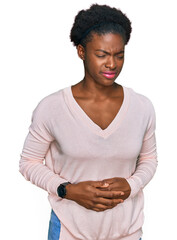 Wall Mural - Young african american girl wearing casual clothes with hand on stomach because indigestion, painful illness feeling unwell. ache concept.