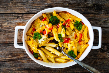 Wall Mural - Noodle casserole with mozzarella cheese and vegetables on wooden table
