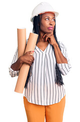 Poster - Young african american woman wearing architect hardhat holding blueprints serious face thinking about question with hand on chin, thoughtful about confusing idea