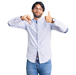 Poster - Handsome hispanic man wearing business shirt and glasses doing thumbs up and down, disagreement and agreement expression. crazy conflict