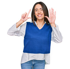 Canvas Print - Young hispanic girl wearing casual clothes showing and pointing up with fingers number seven while smiling confident and happy.