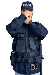 Wall Mural - Young hispanic man wearing police uniform covering eyes and mouth with hands, surprised and shocked. hiding emotion