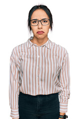 Wall Mural - Young hispanic girl wearing casual clothes and glasses depressed and worry for distress, crying angry and afraid. sad expression.