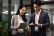 © Ivan - Business partners or employees of finance office, IT sphere, bankers asian beauty man and woman share information about company or discuss financial plan with tablets in hand in office.generative ai