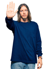 Wall Mural - Handsome caucasian man with long hair wearing casual winter sweater doing stop sing with palm of the hand. warning expression with negative and serious gesture on the face.