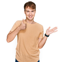 Young caucasian man wearing casual clothes showing palm hand and doing ok gesture with thumbs up, smiling happy and cheerful