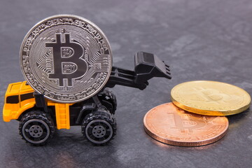 Bitcoins and miniature excavator. Cryptocurrency and international network payment. Finance concept