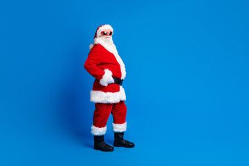 Wall Mural - Full length photo of mature pensioner man touch belt shopping wear trendy santa claus costume coat isolated on blue color background