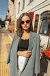 © alones - Successful urban beautiful business girl with vintage sunglasses in fashion clothes walks on a sunny spring day in the city