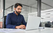 © insta_photos - Busy professional Indian business man employee looking at laptop computer, businessman office worker or executive manager analyzing project strategy working online with ai software at work desk.