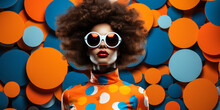 Stylish And Bold Woman With A Retro Afro Hairstyle Wearing Futuristic Blue Sunglasses And A Colorful Polka Dot Dress Against A Dynamic Orange And Blue Geometric Background