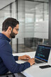 © insta_photos - Busy Indian business man software developer engineer working on laptop computer in office. Male administrator programmer specialist coding on pc developing applications programming code. Vertical.