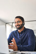 © insta_photos - Smiling Indian call center agent wearing headset talking to client working in customer support office. Professional contract service telemarketing operator using laptop having conversation. Vertical